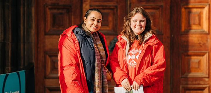 Image of two student ambassadors outside the doors of McEwan Hall